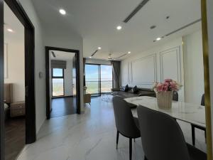 a living room with a table and chairs and a couch at Honeymon vinhomes grand park - 3 phòng ngủ in Gò Công