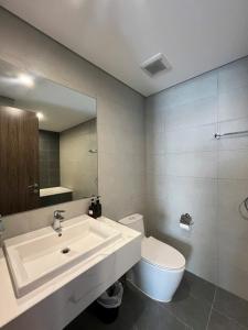 a bathroom with a sink and a toilet and a mirror at Honeymon vinhomes grand park - 3 phòng ngủ in Gò Công