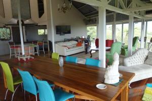 a living room with a wooden table and colorful chairs at Hacienda las Nubes in Turrialba