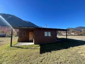 una piccola casa in un campo vicino a una montagna di Cabaña Malalcahuello a Curacautín