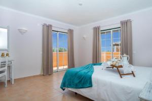 a bedroom with a bed and a desk and windows at Schönes Haus In Carvoeiro Mit Privatem Parkplatz in Sesmarias