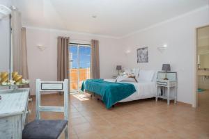 a bedroom with a bed and a large window at Schönes Haus In Carvoeiro Mit Privatem Parkplatz in Sesmarias