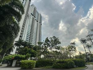 Un edificio alto con árboles delante. en Green haven Studio unit with balcony and WiFi Netflix, en Masai
