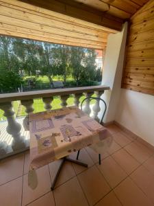 a balcony with a table and a window at Fészek apartmanok in Tiszafüred