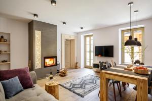 a living room with a couch and a table and a fireplace at Holiday Home Patchwork Barn in Zakopane