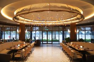 a dining room with tables and a large chandelier at Dragon Villa 3 Bedroom - Sonasea Vân Đồn Harbor City in Thâm Câu