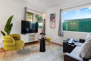a living room with a television and a yellow chair at Cozy 2-Bedroom Retreat in Pacifica in Pacifica