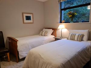 two beds in a room with a window at Glendalough Sanctuary in Brockagh +25 photos