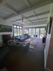 un salon avec des canapés et une table basse dans l'établissement Orira River Cottage, à Umawera