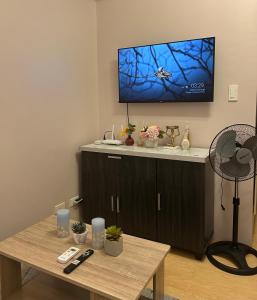 a living room with a table and a flat screen tv at 14F Deluxe Unit at Sunvida Tower across SM CITY in Cebu City