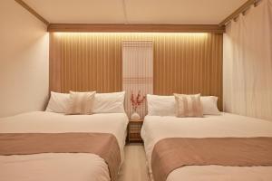 two beds in a room with a window at Zen House,Jamsil Seoul in Seoul