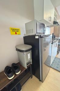 a kitchen with a black refrigerator and a trash can at 14F Deluxe Unit at Sunvida Tower across SM CITY in Cebu City +2 photos