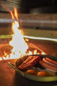 a pan with sausage and eggs in front of a fire at 1980 fuji yamanakako in Yamanakako