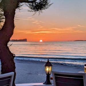 a street light on the beach at sunset at Dolphin Apt & Studios -Near the Beach in Roda