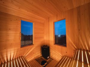 an empty room with two windows in a sauna at Hole 37 in Tsukuba