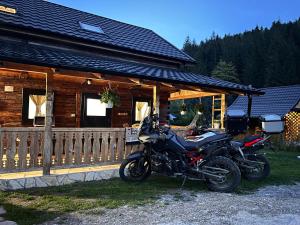 Dreptu de JosCăsuța Dor de Munte的停在小木屋前的摩托车