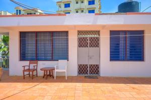 ein kleines weißes Haus mit Stühlen und einem Tisch in der Unterkunft Modern Apartments Nyali in Mombasa