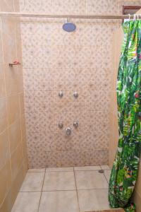 eine Dusche mit Duschvorhang im Bad in der Unterkunft Modern Apartments Nyali in Mombasa