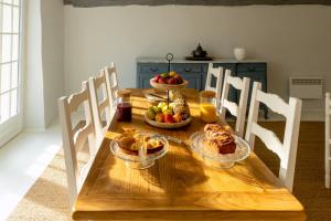 a wooden table with bowls of fruit on it at Domaine des grands chênes in Préveranges