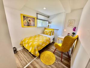 Un dormitorio pequeño con una cama amarilla y una silla amarilla. en Private Room on the 1st floor with a Shared Bathroom 10 minutes from SeaTac Airport, en Seattle