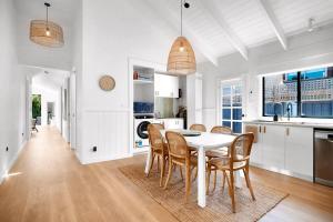 a kitchen and dining room with a white table and chairs at Sandcastle Coastal Retreat in Barwon Heads +4 photos
