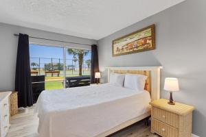 a bedroom with a bed and a large window at Plantation Palms 6103 in Gulf Highlands