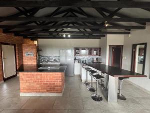 a kitchen with a counter and a bar with stools at Seepraal luxury accommodation in Jeffreys Bay