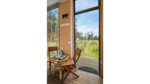 FlowerdaleAlpaca Tiny House with Vineyard Lakeside by Tiny Away的通往带桌椅的天井的门