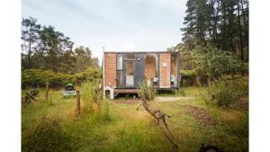 FlowerdaleAlpaca Tiny House with Vineyard Lakeside by Tiny Away的田间中的小房子