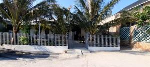 a white gate in front of a house with palm trees at Sandy Homestay-Vĩnh Hy in Ninh Hải +4 photos