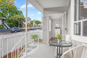 a balcony with a table and a view of a street at Charming Cottage Short Distance to CBD with Parking in Brisbane