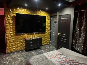 トゥーロンにあるLove Room, La Parenthèse Toulonの黄色の壁と薄型テレビのある寝室