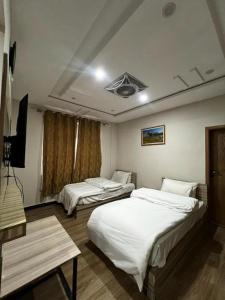 Cette chambre comprend 2 lits et une télévision. dans l'établissement Skardu Midway Hotel, à Skardu