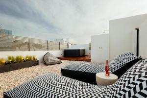 a living room with a couch and pillows on a balcony at Num Suites & Lofts Athens in Athens
