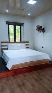a bedroom with a large white bed with a window at Tran Chau Garden Home in Cat Ba