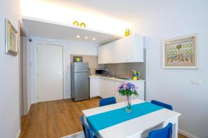 Una cocina con una mesa con un jarrón de flores encima. en Apartment downtown, near Pompei Sorrento ,the sea, en Portici 24 fotos más