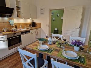 ゴスラーにあるApartment Piepmäker mit Parkplatz und Kamin, Bahnhof fußläufigのキッチン(木製テーブル、皿、ワイングラス付)