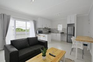 a living room with a couch and a table at Apartment 2-bedroom #3 Leetch Views in Cape Town