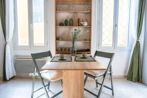 a dining room with a wooden table and two chairs at Studio élégant et cosy in Manosque