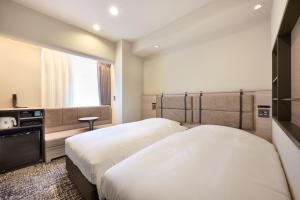 Postel nebo postele na pokoji v ubytování Via Inn Shinjuku