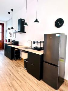 een keuken met een roestvrijstalen koelkast en een klok aan de muur bij Mediterranean Apartament in Valencia +9 foto's