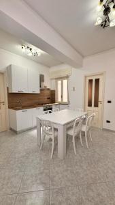 a kitchen with a white table and chairs at Casa Vacanza Stella in Torre Forte