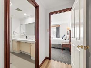 Un dormitorio con una cama y un baño con espejo. en Marguerite Studio - central town & pool, en Margaret River Town 4 fotos más