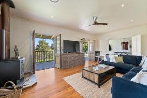 a living room with a blue couch and a tv at South Haven in Upper Kangaroo River