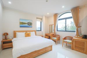 a bedroom with a large bed and a window at Cerasoi Boutique Dalat Hotel in Da Lat