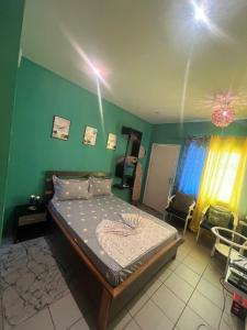 a bedroom with a bed and a green wall at Studio Moderne à Pointe-Noire in Pointe-Noire