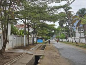 a person walking down a street with trees at Studio Moderne à Pointe-Noire in Pointe-Noire