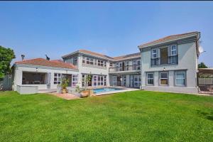 an exterior view of a large house with a yard at Cape Golf Villa in Cape Town