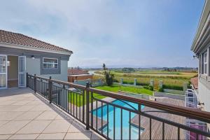 a house with a balcony with a swimming pool at Cape Golf Villa in Cape Town