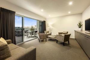 a living room with a couch and chairs and a television at Quest Bundoora in Melbourne